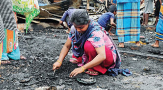 Burnt furniture and charred clothes -- all that remain of their hopes and dreams, shattered by yesterday’s blaze at the slum near port city’s Amin colony. This photo of a woman trying to salvage her belongings was taken yesterday. Photo: Star