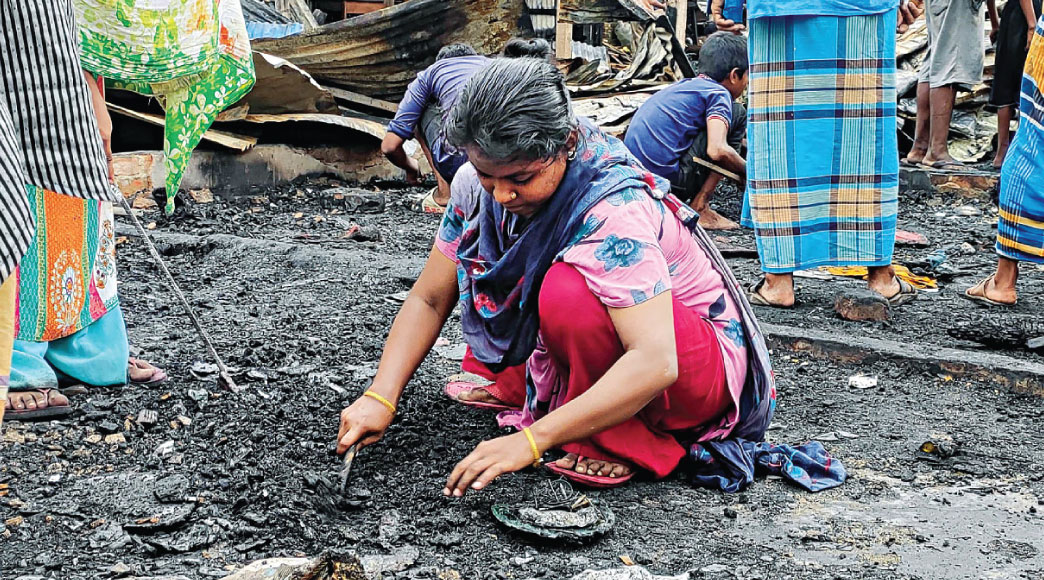 Burnt furniture and charred clothes -- all that remain of their hopes and dreams, shattered by yesterday’s blaze at the slum near port city’s Amin colony. This photo of a woman trying to salvage her belongings was taken yesterday. Photo: Star